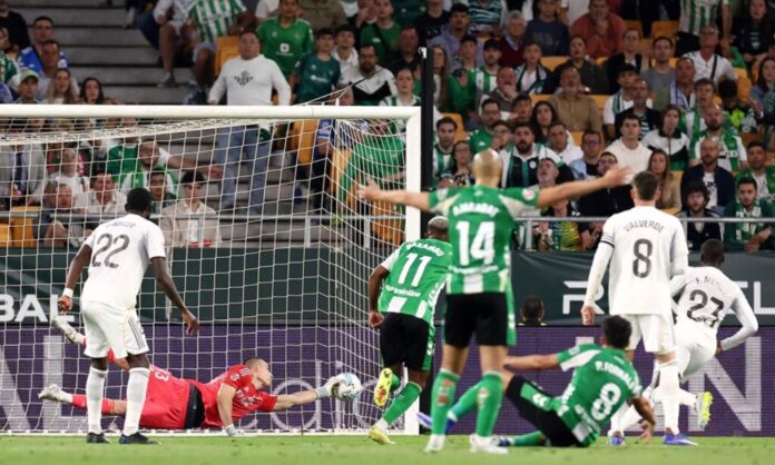 Andriy Lunin, estirándose para realizar una parada en el partido de este viernes contra el Betis en La Cartuja.