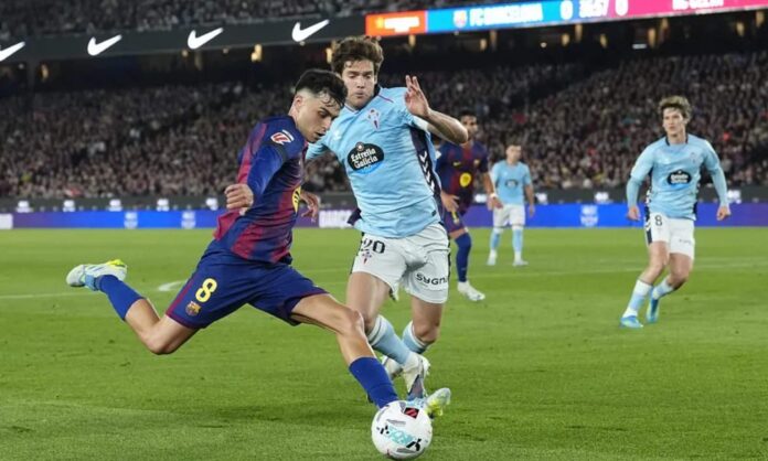 Pedri se dispone a dar un centro defendido por Marcos Alonso, en el encuentro de esta noche entre el Barcelona y el Celta de Vigo.