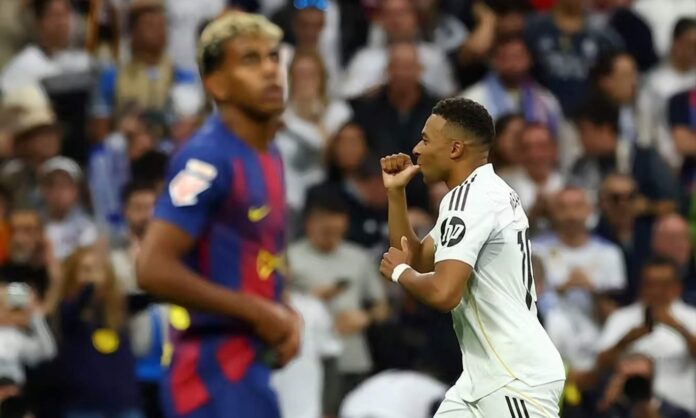 Kylian Mbappé, marcando un gol en uno de los últimos Clásicos, delante de Lamine Yamal.