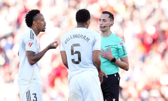 El colegiado José María Sánchez Martínez, hablando con Éder Militao y Jude Bellingham en un partido del Real Madrid durante esta temporada.