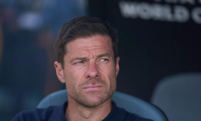 Xabi Alonso sentado en el banquillo con un rostro serio.